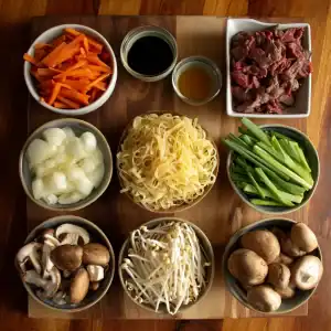 A wooden board holds bowls with ingredients for Beef Chow Fun: sliced carrots, soy sauce, sliced beef, chopped onions, egg noodles, green onions, mushrooms, and bean sprouts—all neatly arranged from above.