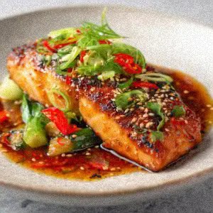 Asian Glazed Salmon fillet garnished with sliced green onions, red chili, and sesame seeds, served on a plate with a soy-based sauce and fresh vegetables.