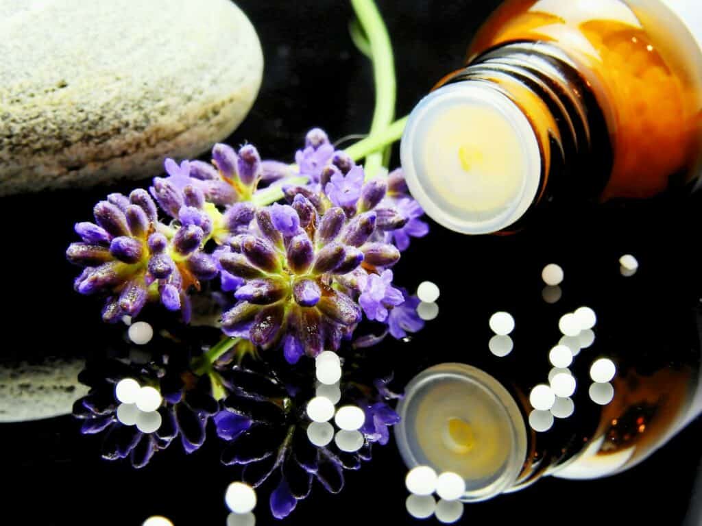 Alternative Medicine, Lavender flowers with herbal homeopathy on a reflective surface, ideal for natural therapy themes.