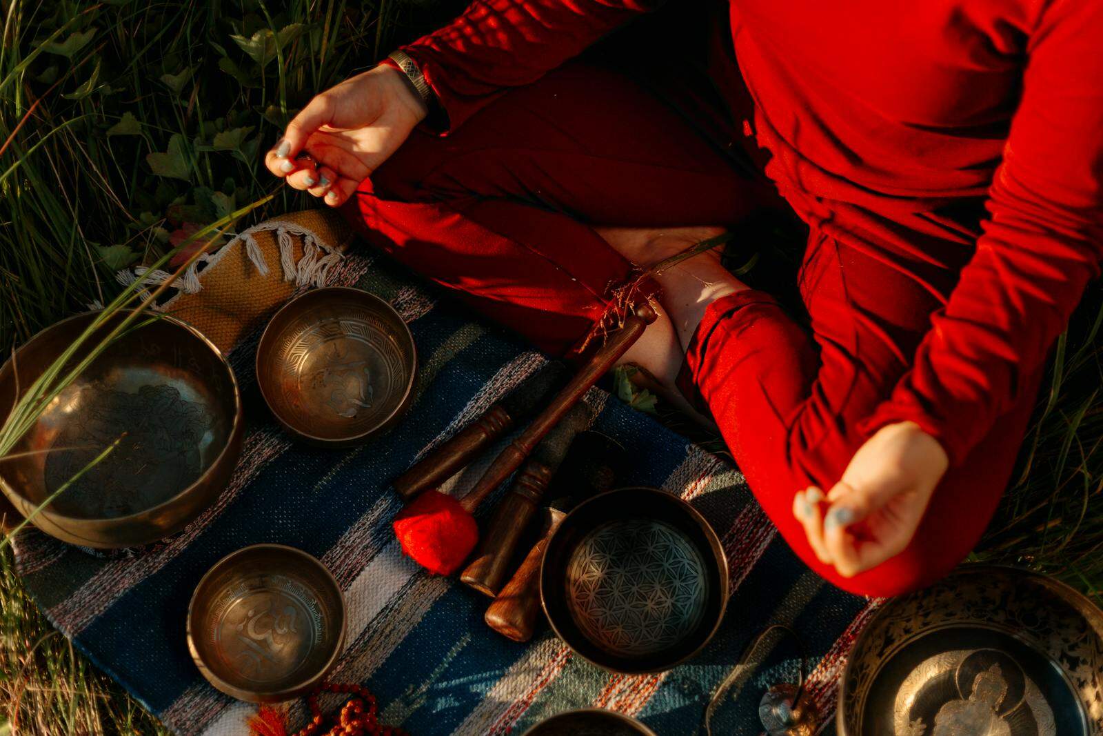 Ayurveda, Holistic Health, A person meditating outdoors with Tibetan singing bowls, creating a peaceful atmosphere.