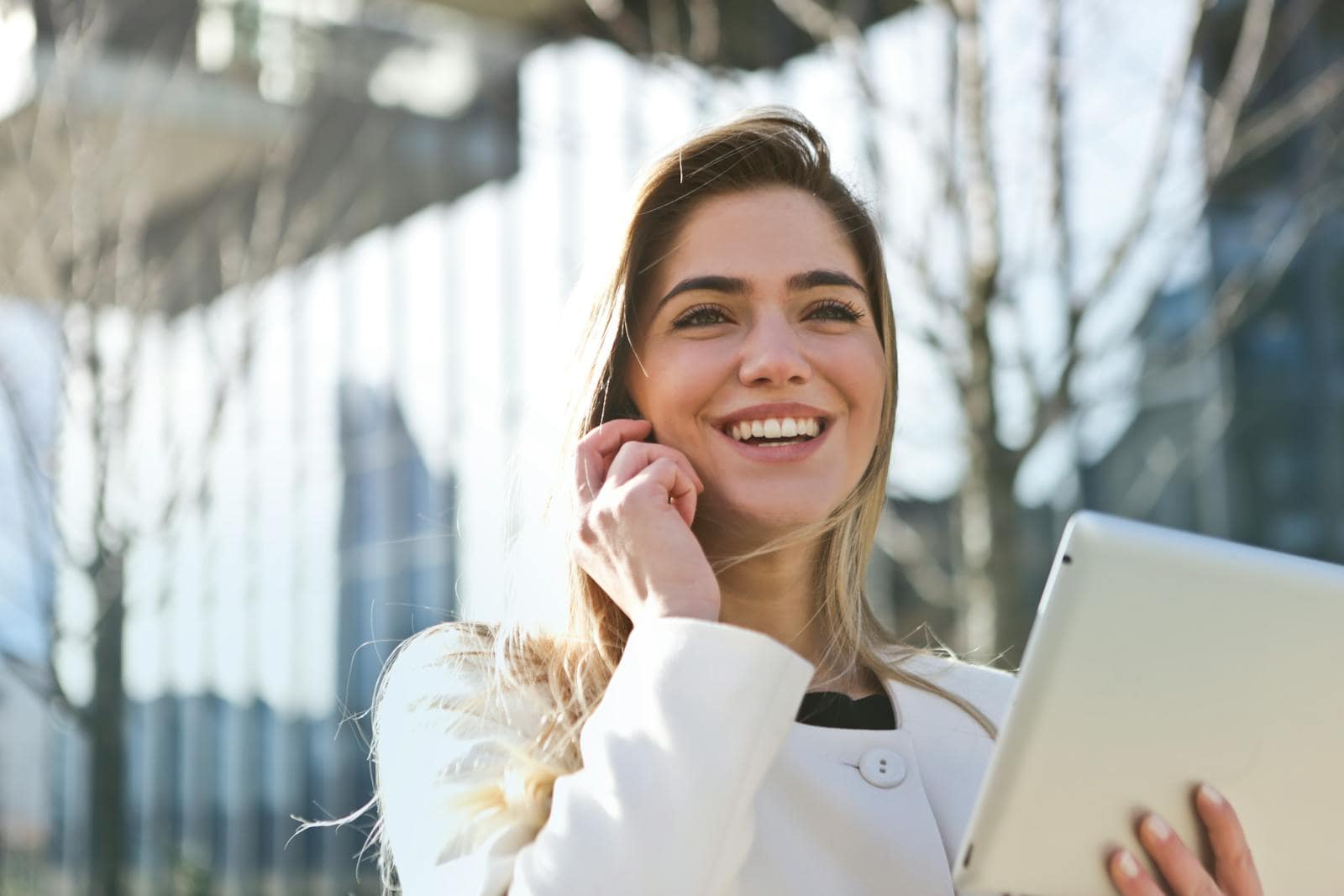 Horoscope, reading, success, astrology, Confident businesswoman using her tablet and phone, smiling outdoors in sunlight.