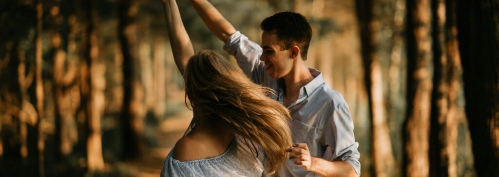 man and woman dancing at center of trees