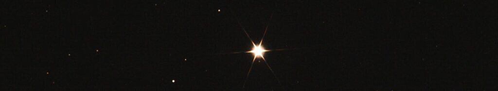 A single bright star shining in a dark, clear night sky with scattered distant stars.