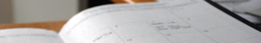 open monthly planner on wooden desk