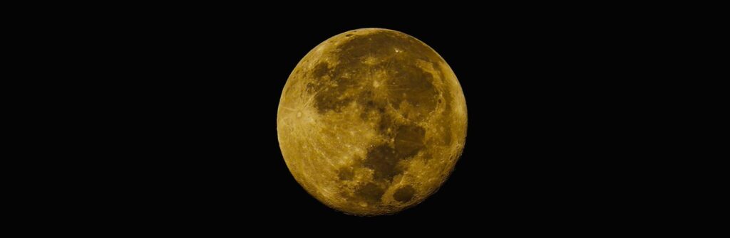 Crisp photo of a full moon with visible craters set against a clear black night sky.