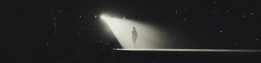 a black and white photo of a person standing in the dark