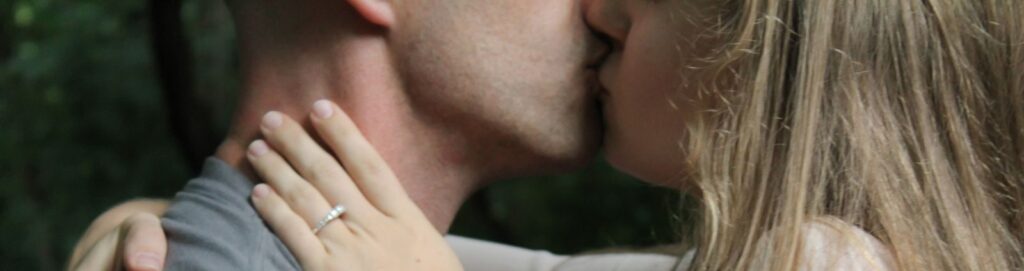 Close-up of a couple kissing outdoors, highlighting love and affection.