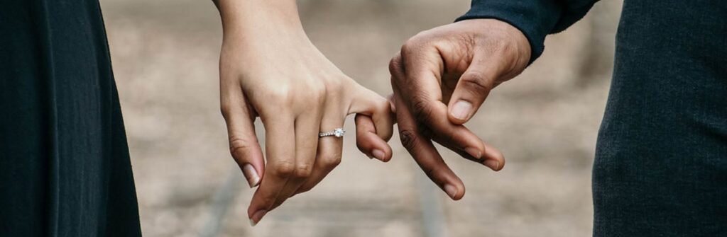 A romantic couple holding hands, symbolizing love and unity on a scenic railtrack.