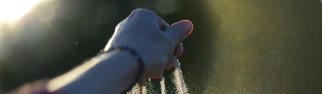 A person holding their hand out to spray water