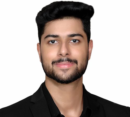 Young man with well-groomed beard and black suit, professional headshot for Astro Vastu House.