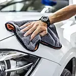 Person cleaning car with cloth