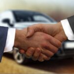 Potřesení rukou při koupi auta – prodejce a zákazník u vozu v autobazaru