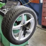 Přezouvání pneumatik v autoservisu – mechanik kontroluje letní pneumatiku