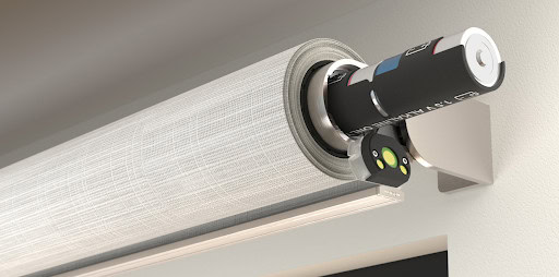Sleek, white, wireless Lutron shading systems work noiselessly atop a window.