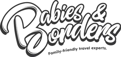 A family with young children exploring a park, holding hands and enjoying nature.