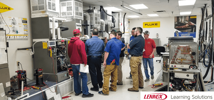 Technicians participating in hands-on HVAC training at the Lennox Learning Solutions facility with detailed product demonstrations.