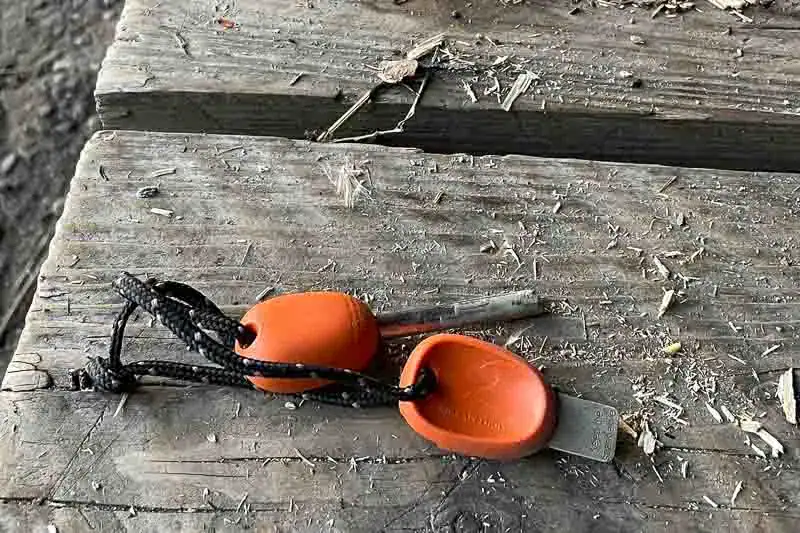 To orange ildstål ligger på et træbord dækket af spåner.