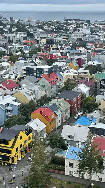 Farverige huse i Reykjavik set fra oven, med havet i baggrunden