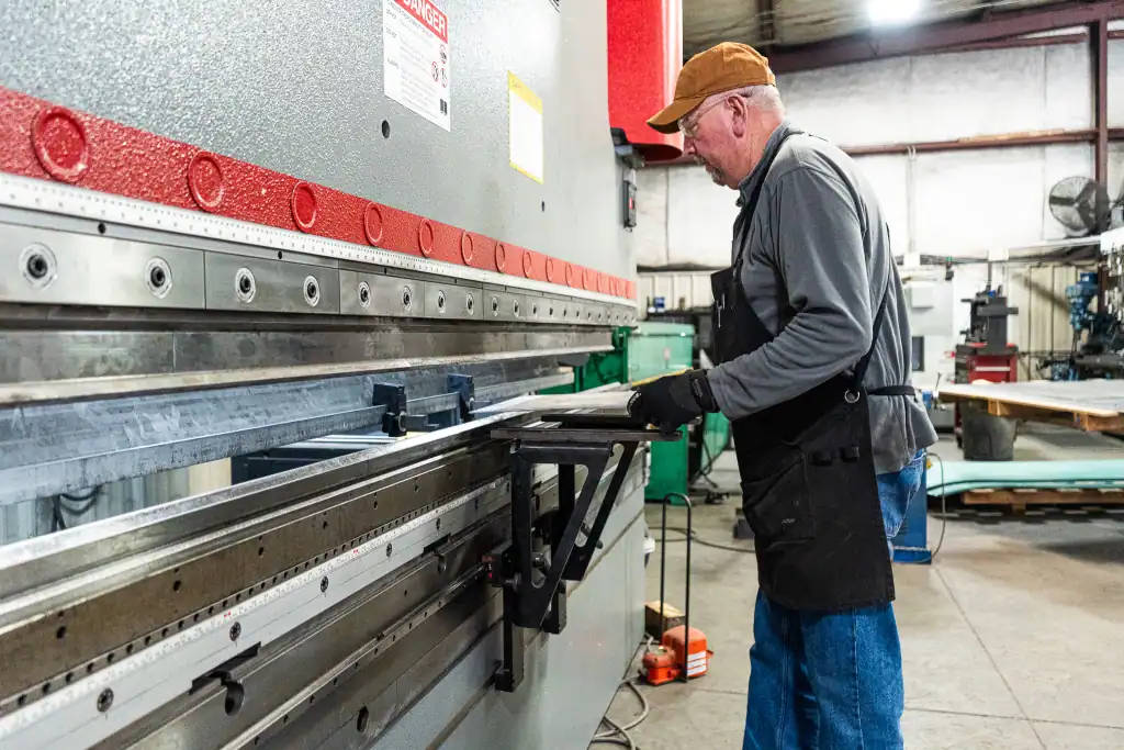 Skilled worker operating a metal press at B&B Powder Metal.