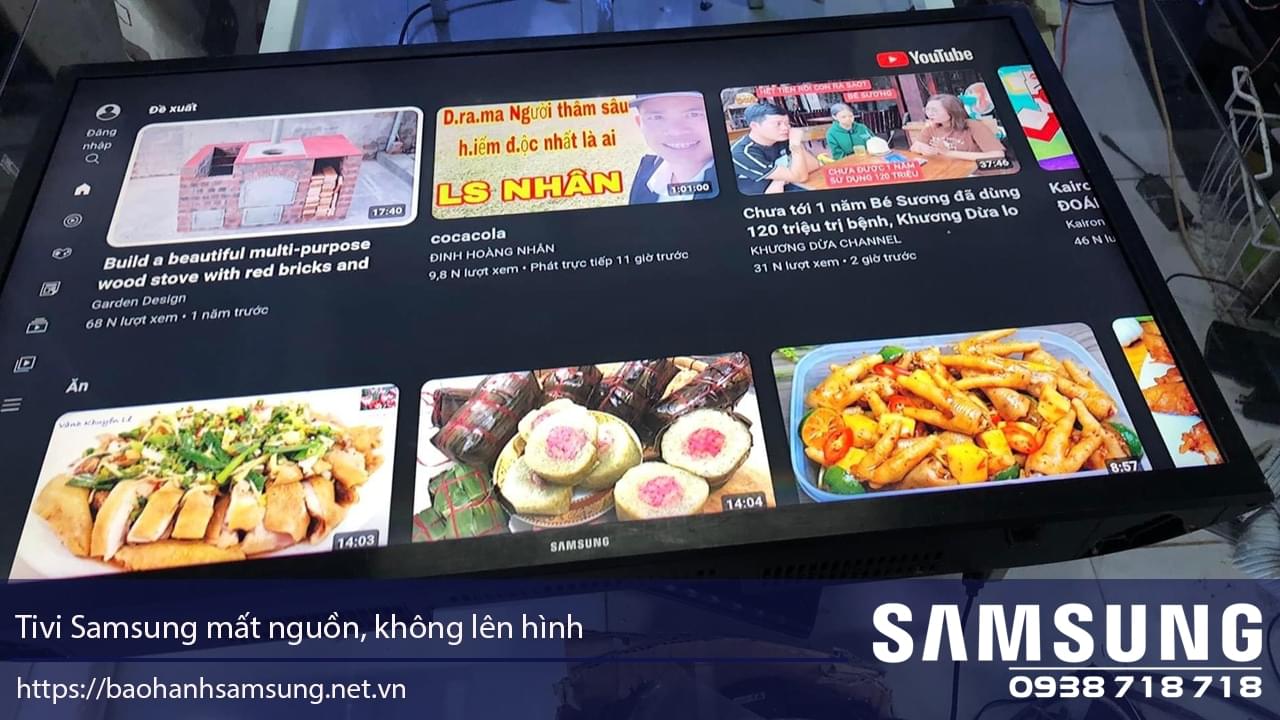 Build a Samsung TV with a black screen showing YouTube videos and food thumbnails, placed on a glass table, with the Samsung logo and contact number visible for repair services.