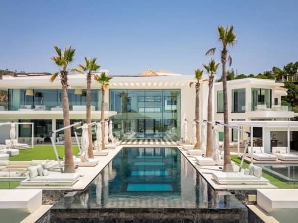 Elegant Marbella estate featuring a modern design, pool, and lush palm trees, exemplifying the coexi.