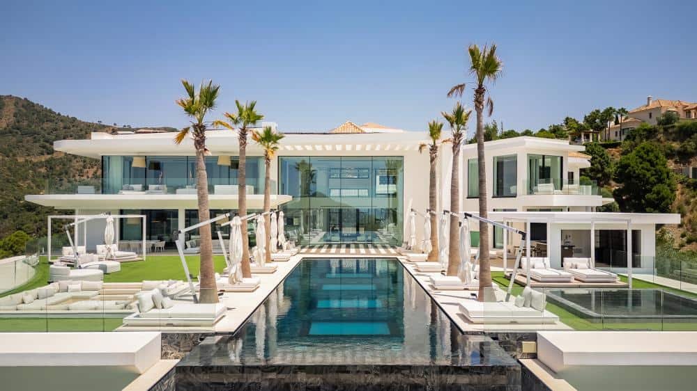 Elegant Marbella estate featuring a modern design, pool, and lush palm trees, exemplifying the coexi.
