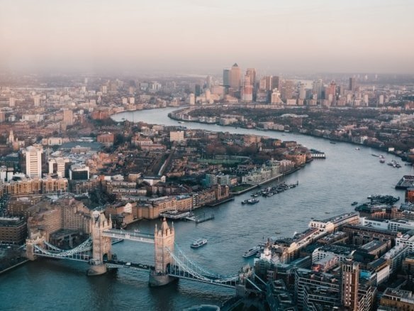 Aerial view of London skyline with Tower Bridge and River Thames at sunset.