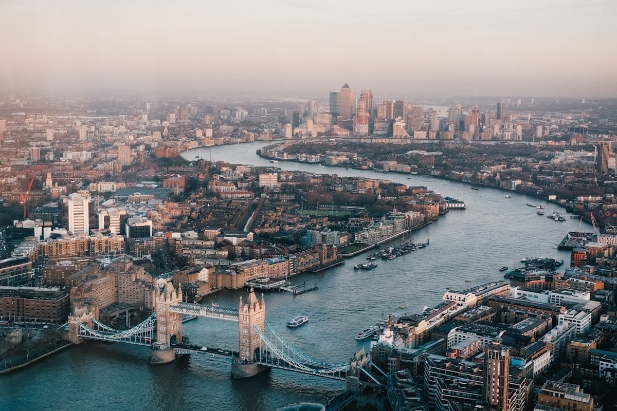 Aerial view of London skyline with Tower Bridge and River Thames at sunset.