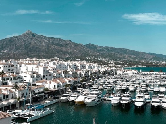 Marina with yachts and boats against scenic mountain backdrop in Cabo San Lucas, Mexico.
