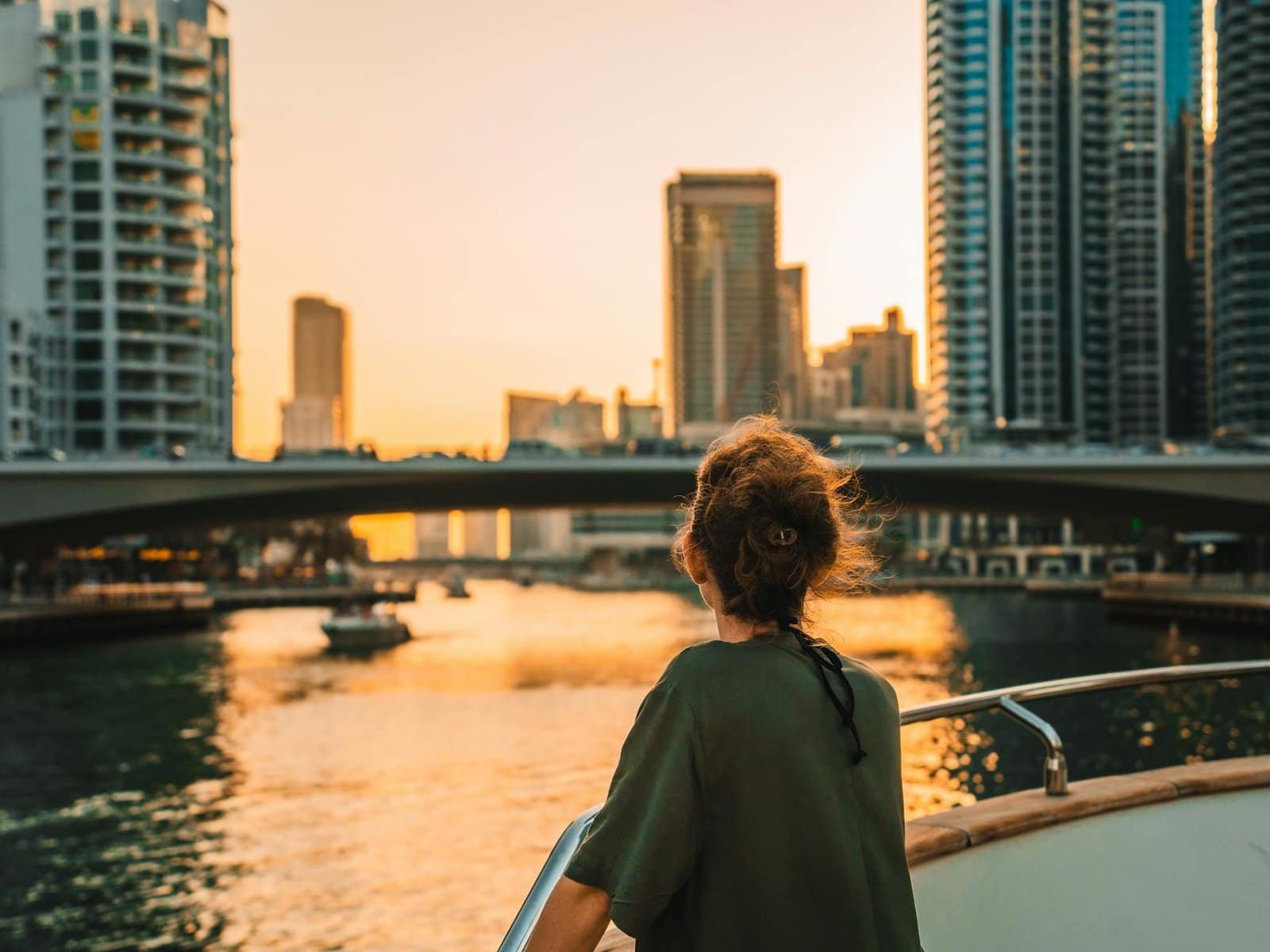 Dubai city skyline with modern skyscrapers and waterfront views during sunset.