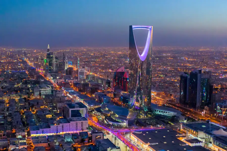 Night view of Riyadh's modern skyline with iconic skyscrapers and vibrant city lights.