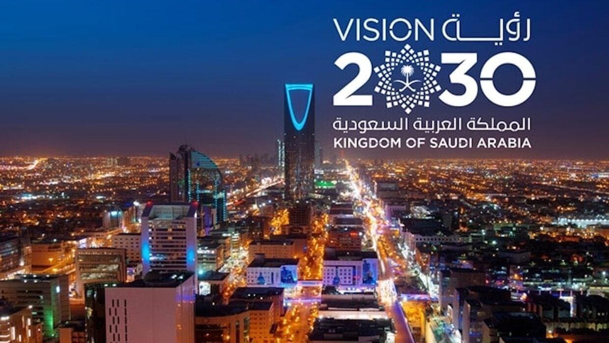 Night view of Riyadh skyline with Vision 2030 logo and city lights.
