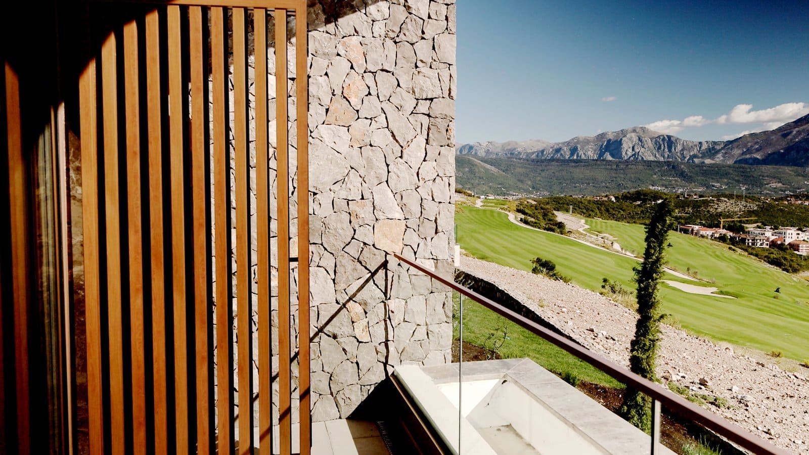 Stunning view of luxury villas and golf course in Montenegro with Adriatic Sea backdrop.