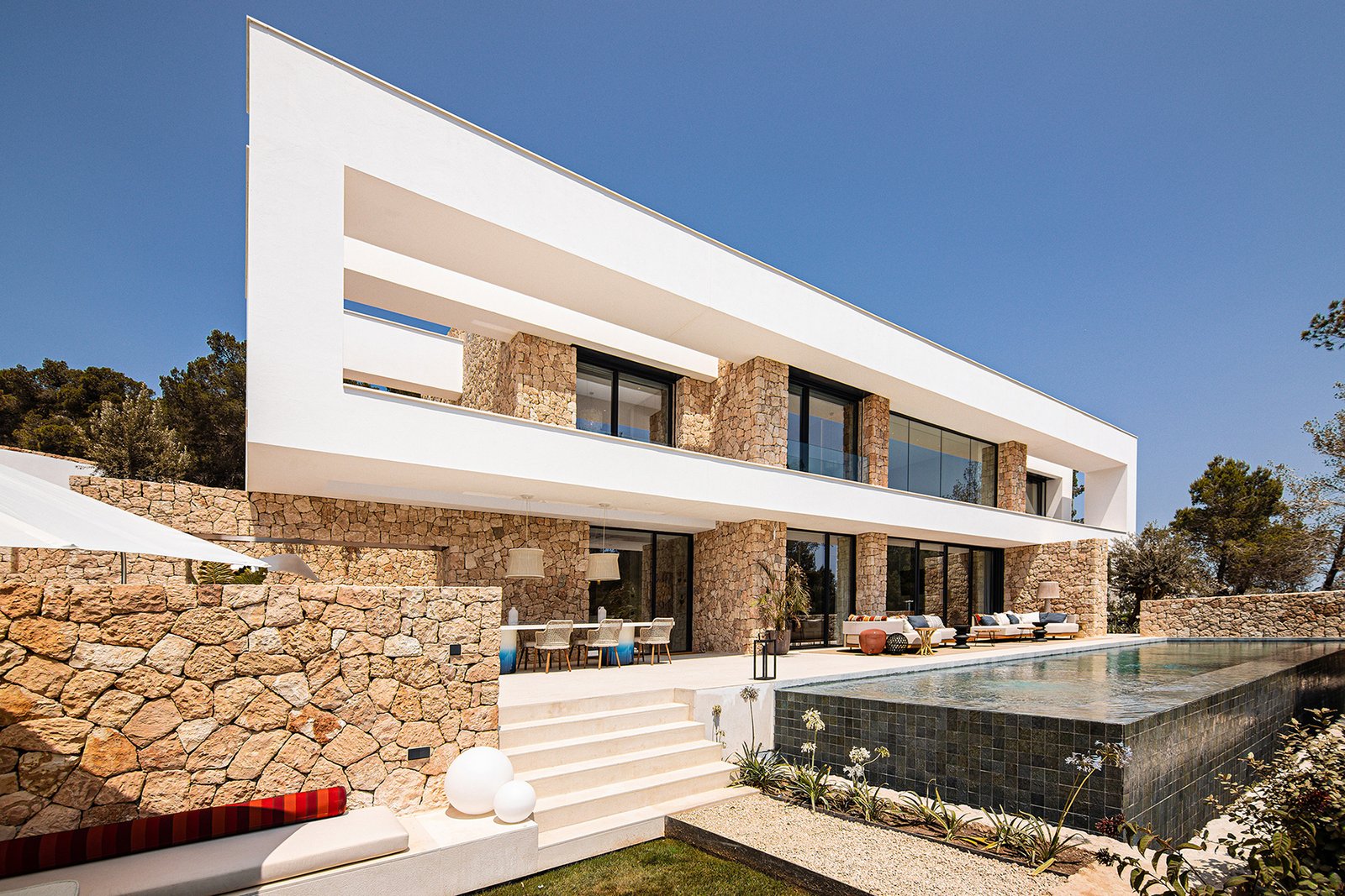 Luxury villa with modern architecture, large terrace, and private pool in Ibiza.