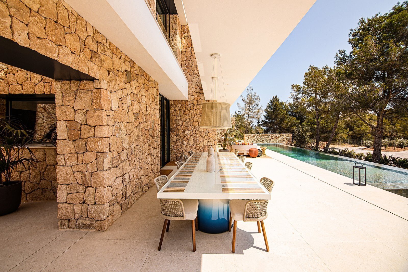 Luxury Ibiza villa outdoor dining with private pool and scenic natural surroundings.