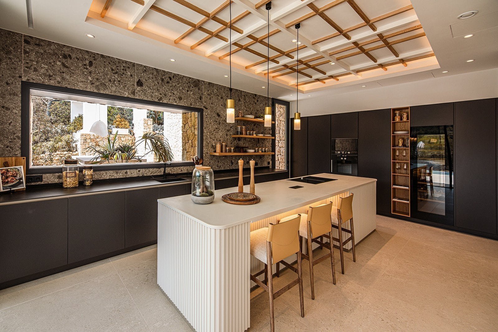 Elegant modern kitchen in Corallisa Ibiza villa with sleek black cabinetry and a spacious island.
