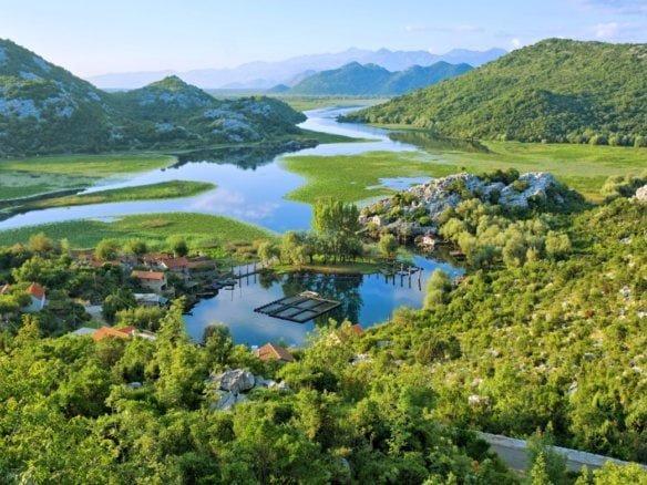 Beautiful lake surrounded by lush green mountains and hills.
