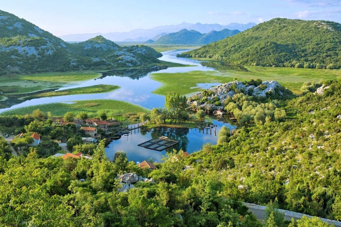 Beautiful lake surrounded by lush green mountains and hills.