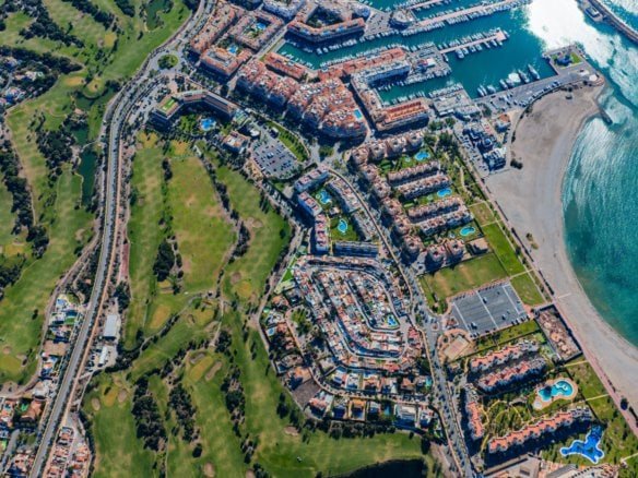 Aerial view of a coastal residential community with green spaces and marina.