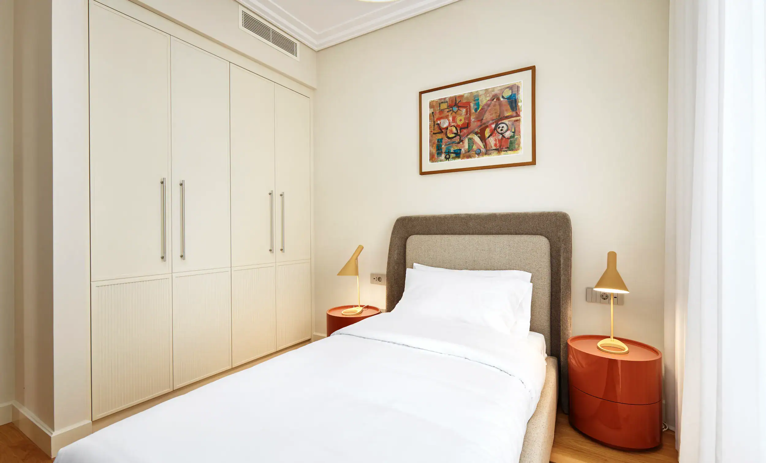 Bedroom interior with minimalist design, white walls, and contemporary furniture in Porto Montenegro.