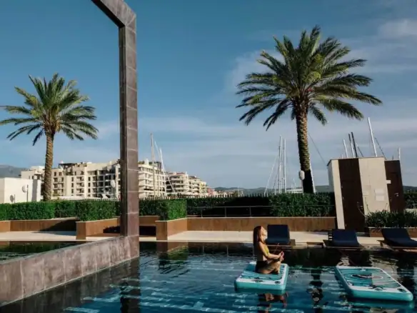 Rooftop pool with palm trees, modern lounge area, and cityscape backdrop at Barok Estates Internatio.