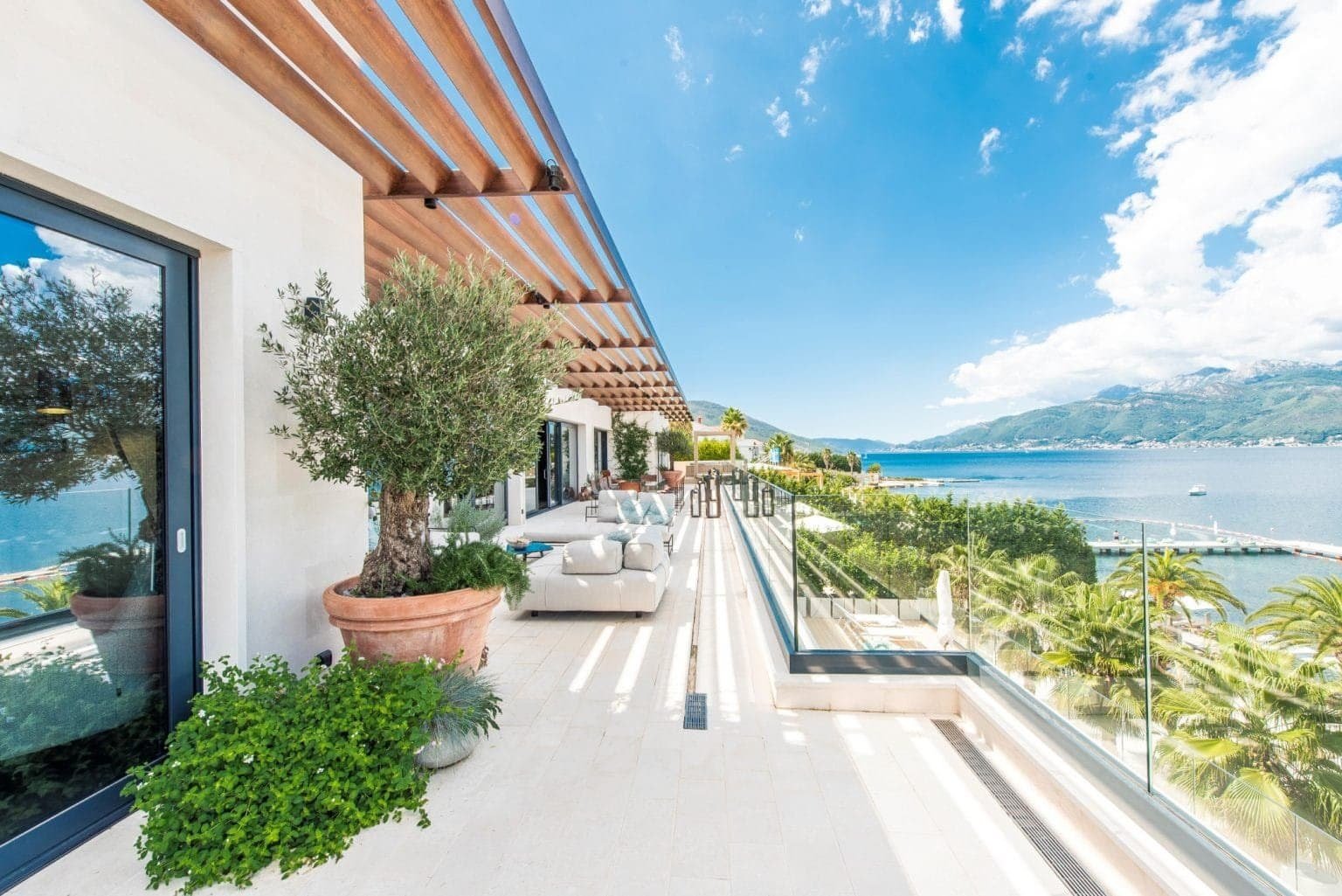Luxury Montenegro waterfront penthouse terrace with sea views and modern outdoor furniture.