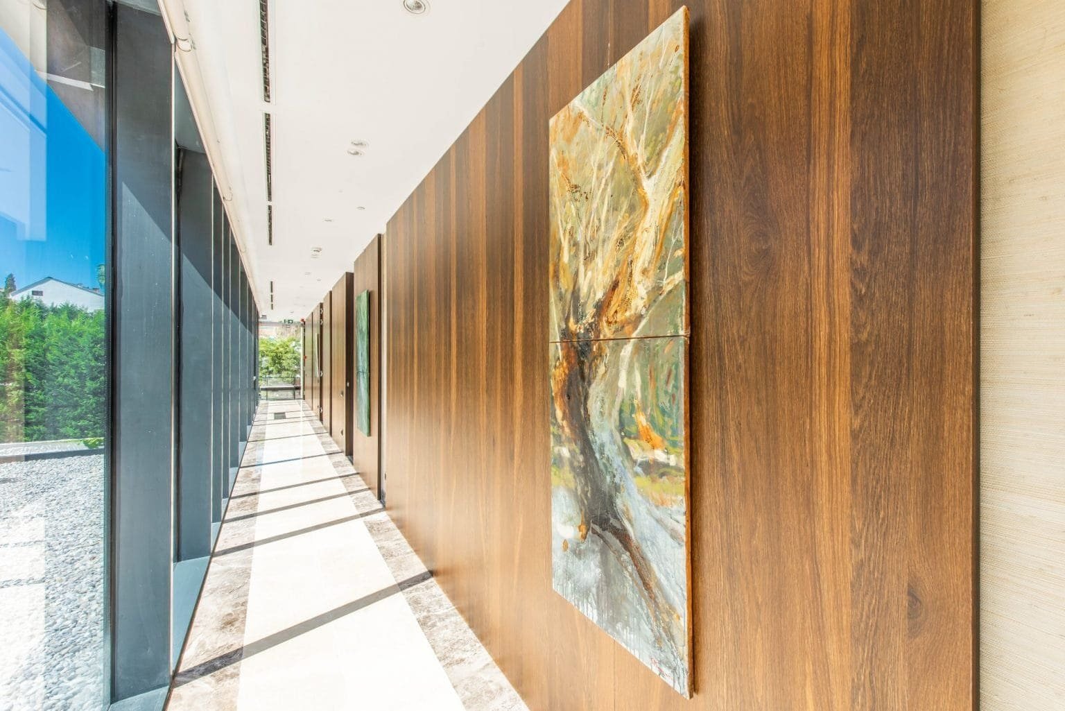 Modern hallway with wooden wall panels and abstract art at Nikki Beach Montenegro waterfront residen.