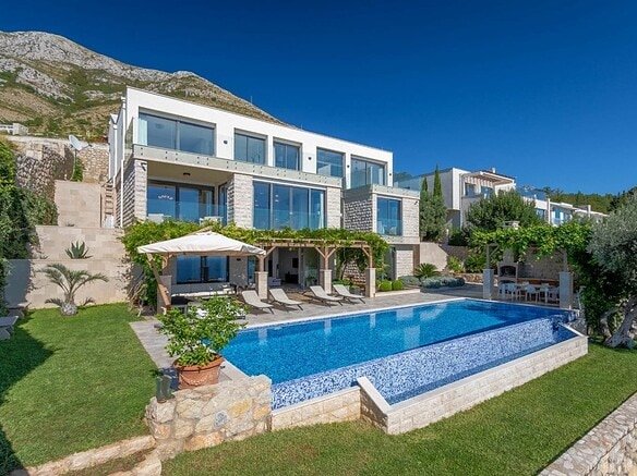 فيلا فاخرة تطل على مناظر بانورامية للخليج في مونتينيغرو، تتميز بتصميم معماري عصري ومسبح خاص.