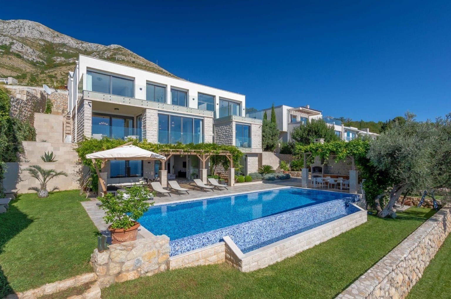 فيلا فاخرة تطل على مناظر بانورامية للخليج في مونتينيغرو، تتميز بتصميم معماري عصري ومسبح خاص.