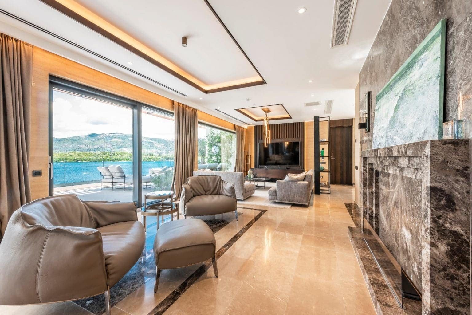 Elegant living room with panoramic lake views in Nikki Beach Montenegro penthouse.
