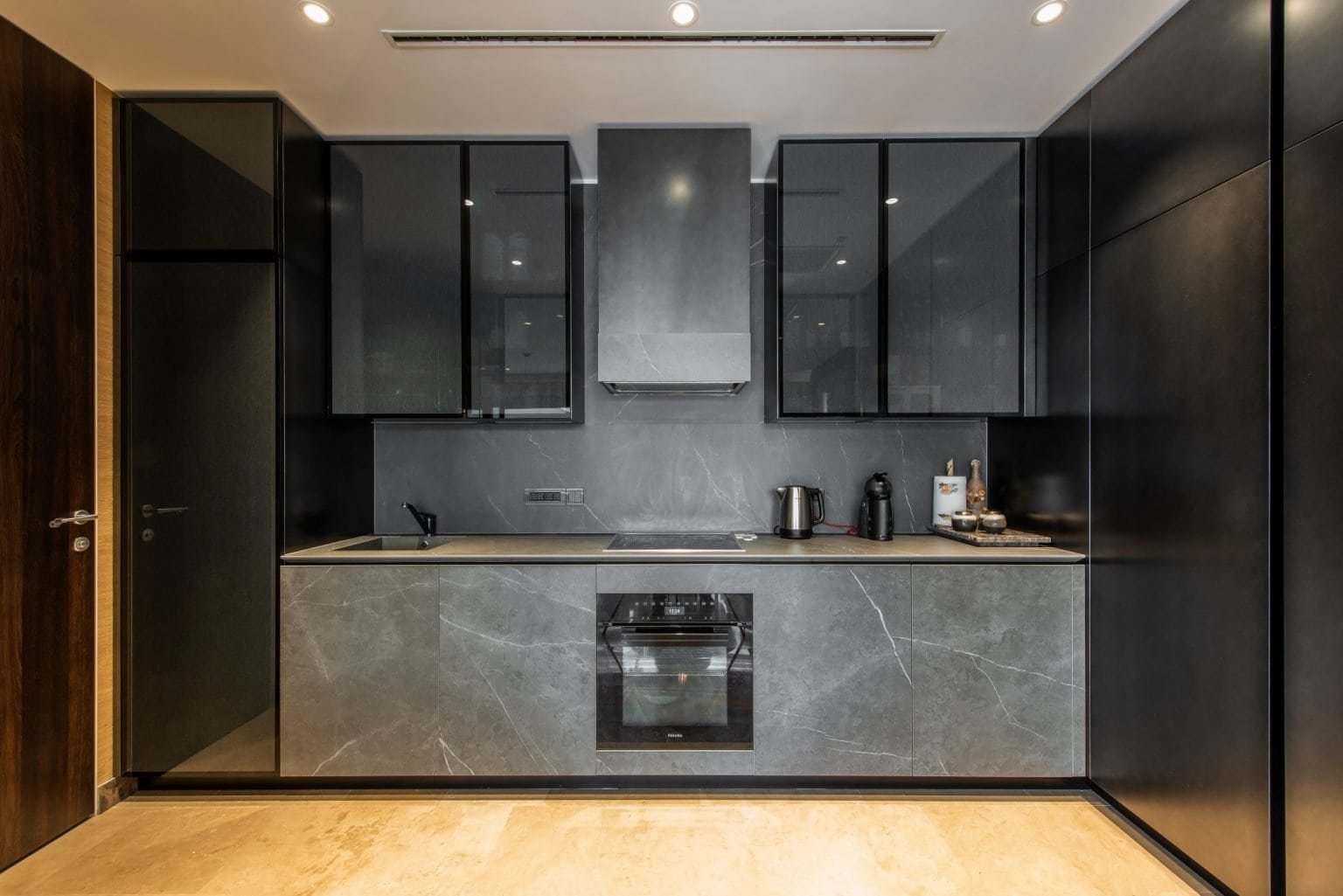 Modern Montenegro penthouse kitchen with sleek black cabinetry and marble countertops in Tivat.