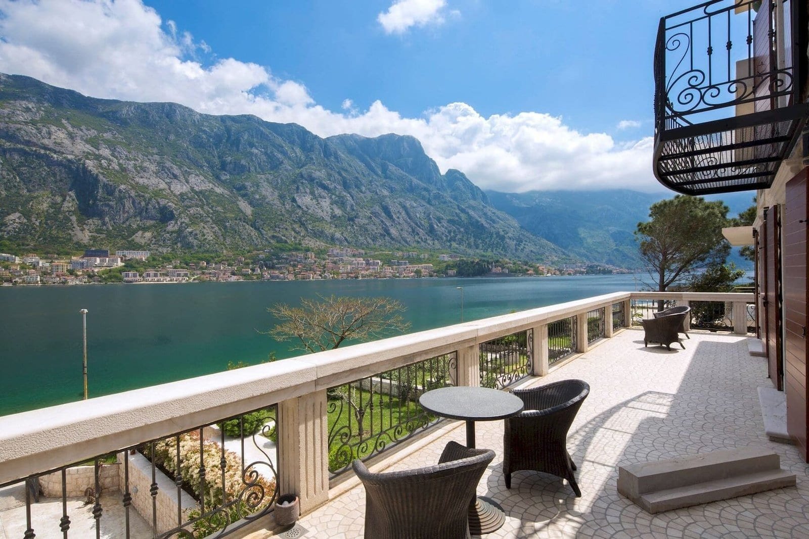 Waterfront stone villa balcony overlooking Boka Bay in Montenegro, with scenic mountain views and ou.
