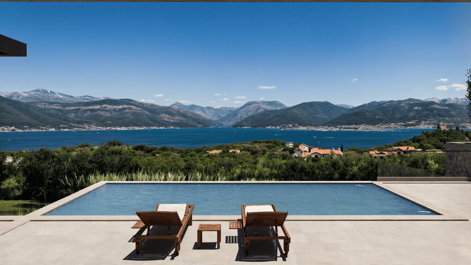 Modern estate featuring an infinity pool overlooking scenic mountains and a lake.