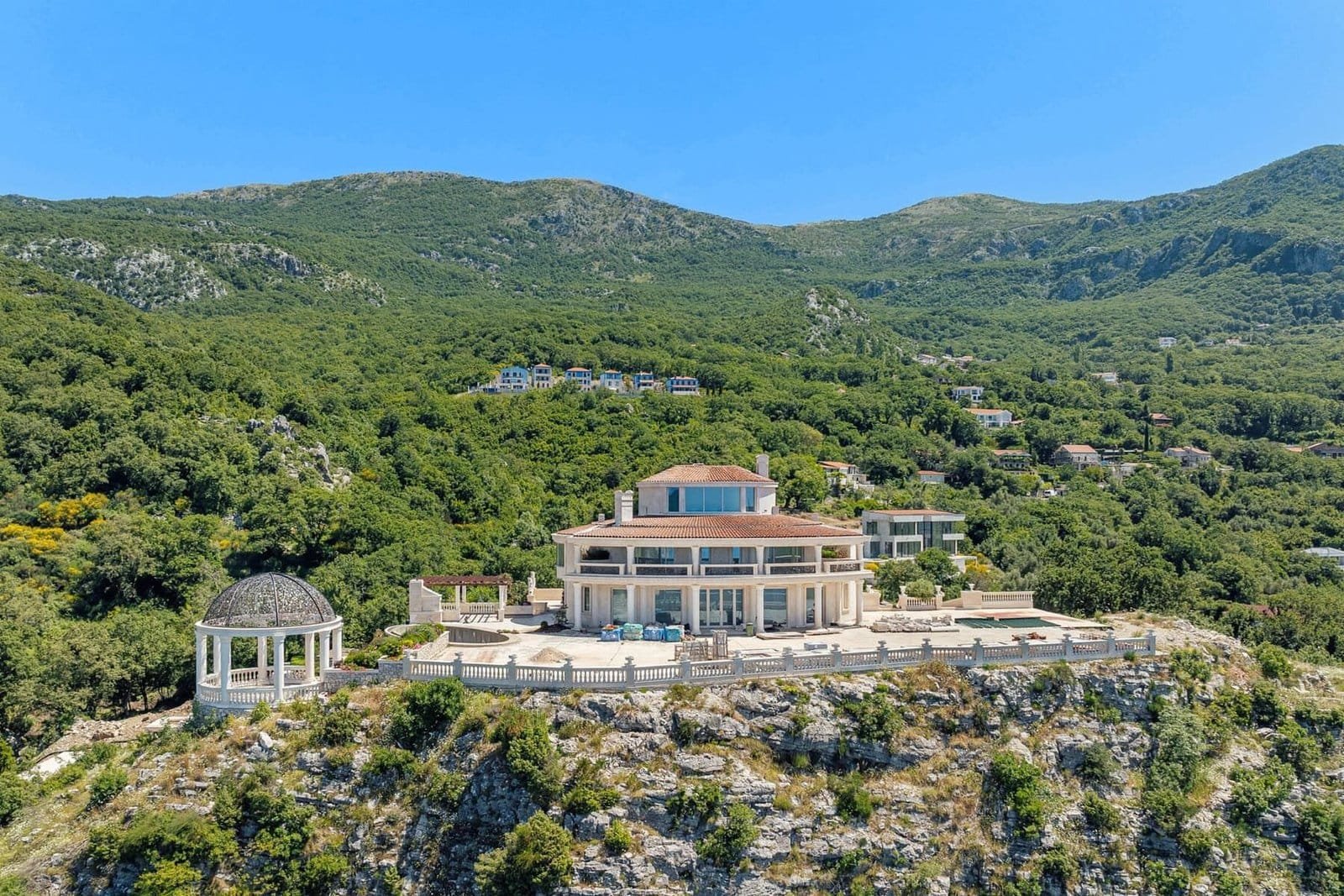 Luxury hillside villa with panoramic sea and mountain views in a private setting.